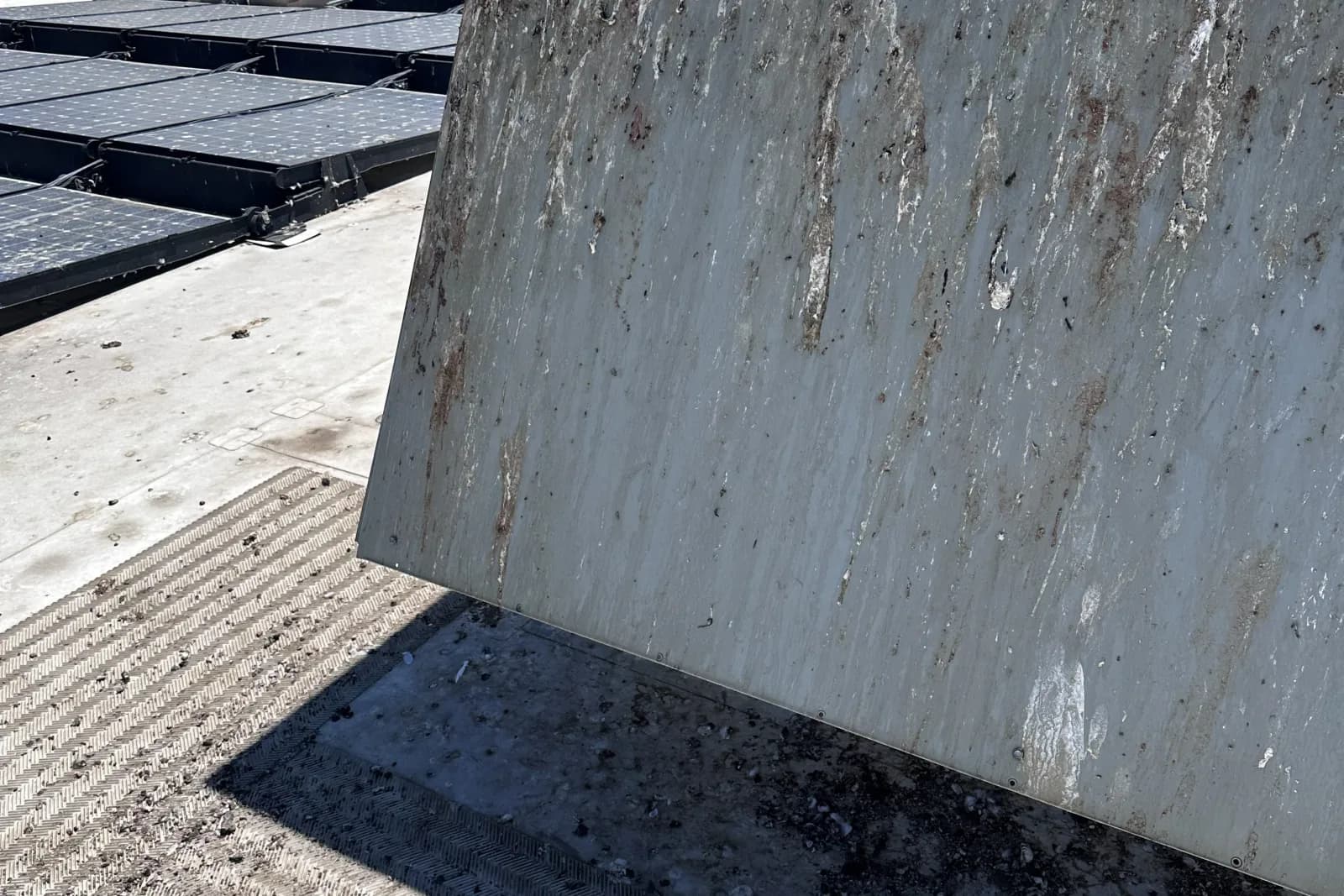 Contaminated commercial rooftop surface covered in bird droppings and debris
